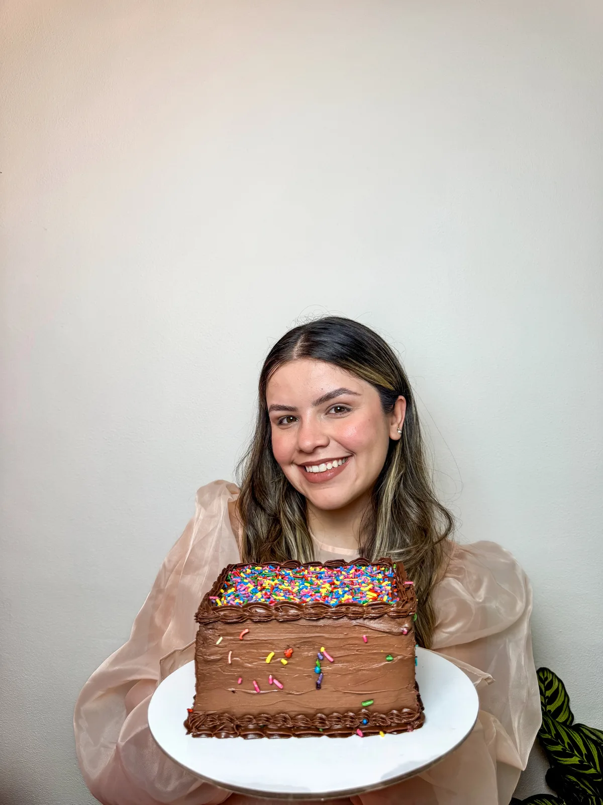 Laura, founder of Doce Afetto, holding a fresh cake